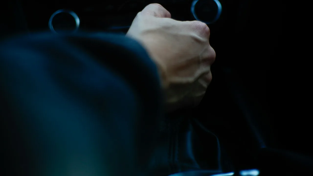 A driver holding a steering wheel