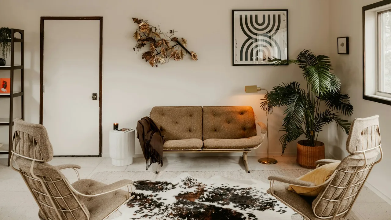 A furnished lounge with a sofa and two chairs