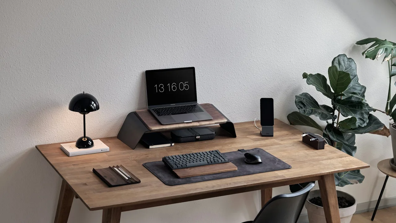 Computer and accessories arranged on a wooden desk