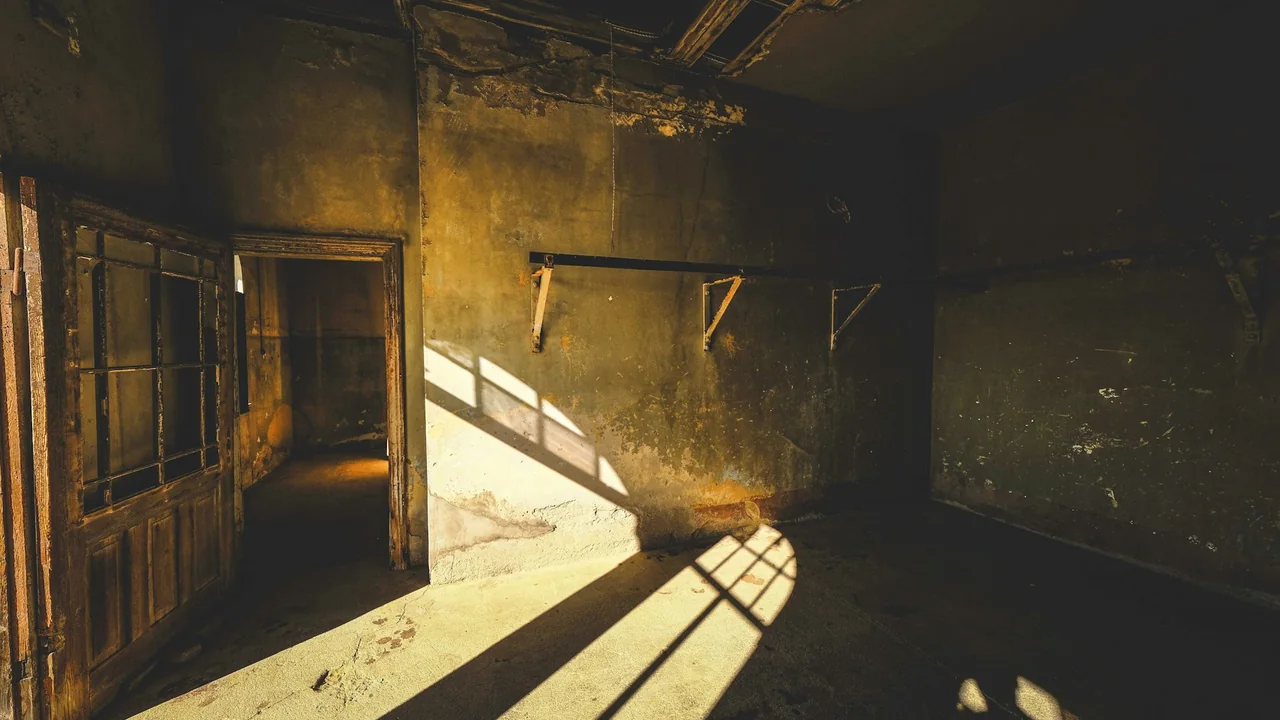 Dim unfinished interior with daylight through large windows