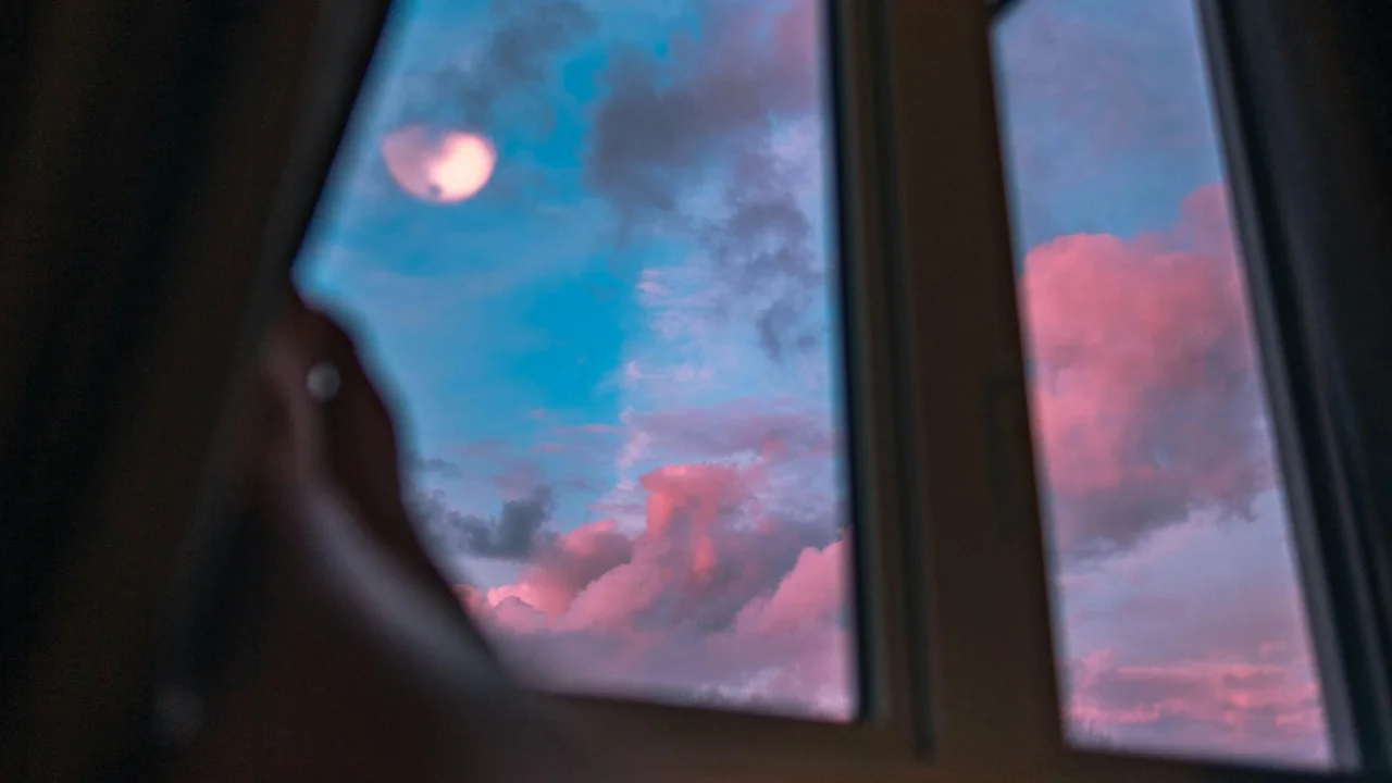 Open window looking towards a pink and blue evening sky